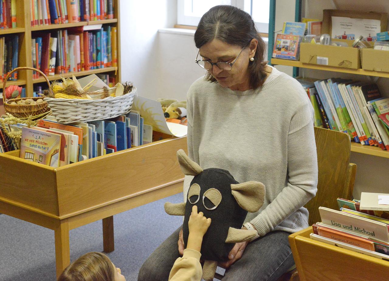 Eine Frau mit einer Maus-Handpuppe auf den Schoß