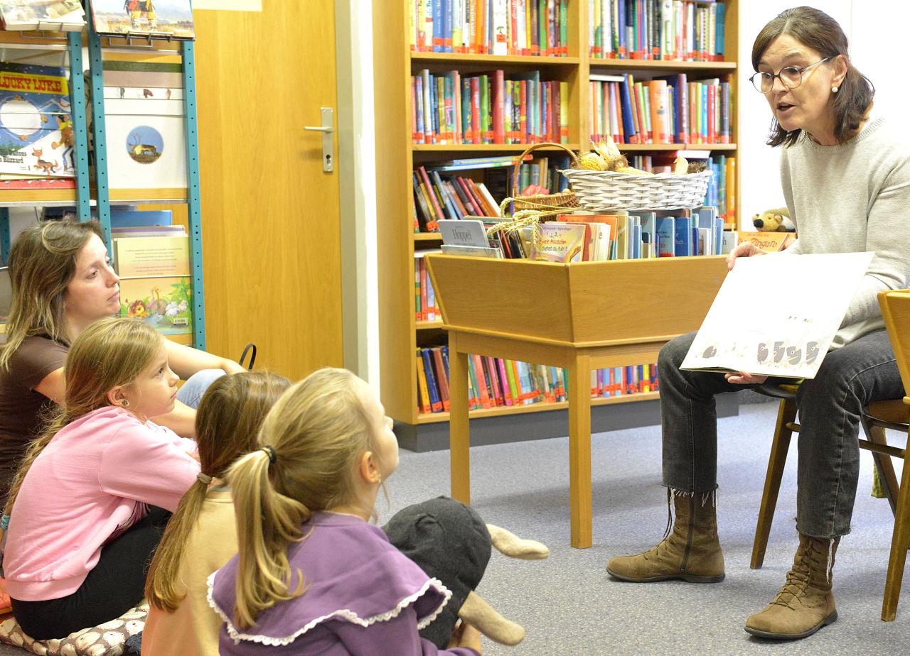 Frau mit aufgeschlagenem Bilderbuch in der Hand