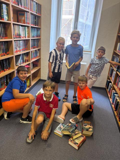 Kinder in Bibliothek mit Büchern