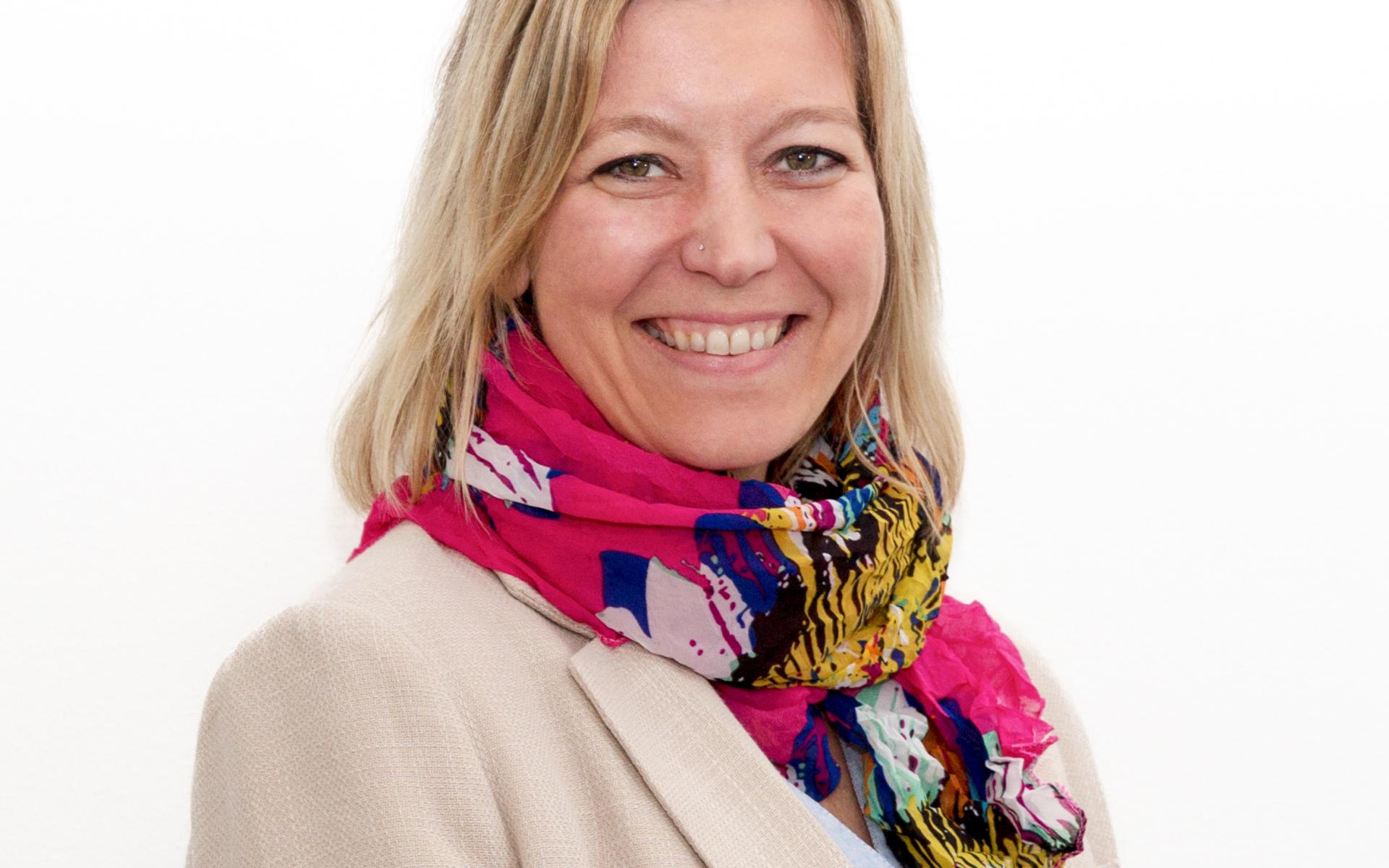 Eine Frau, die in die Kamera lächelt