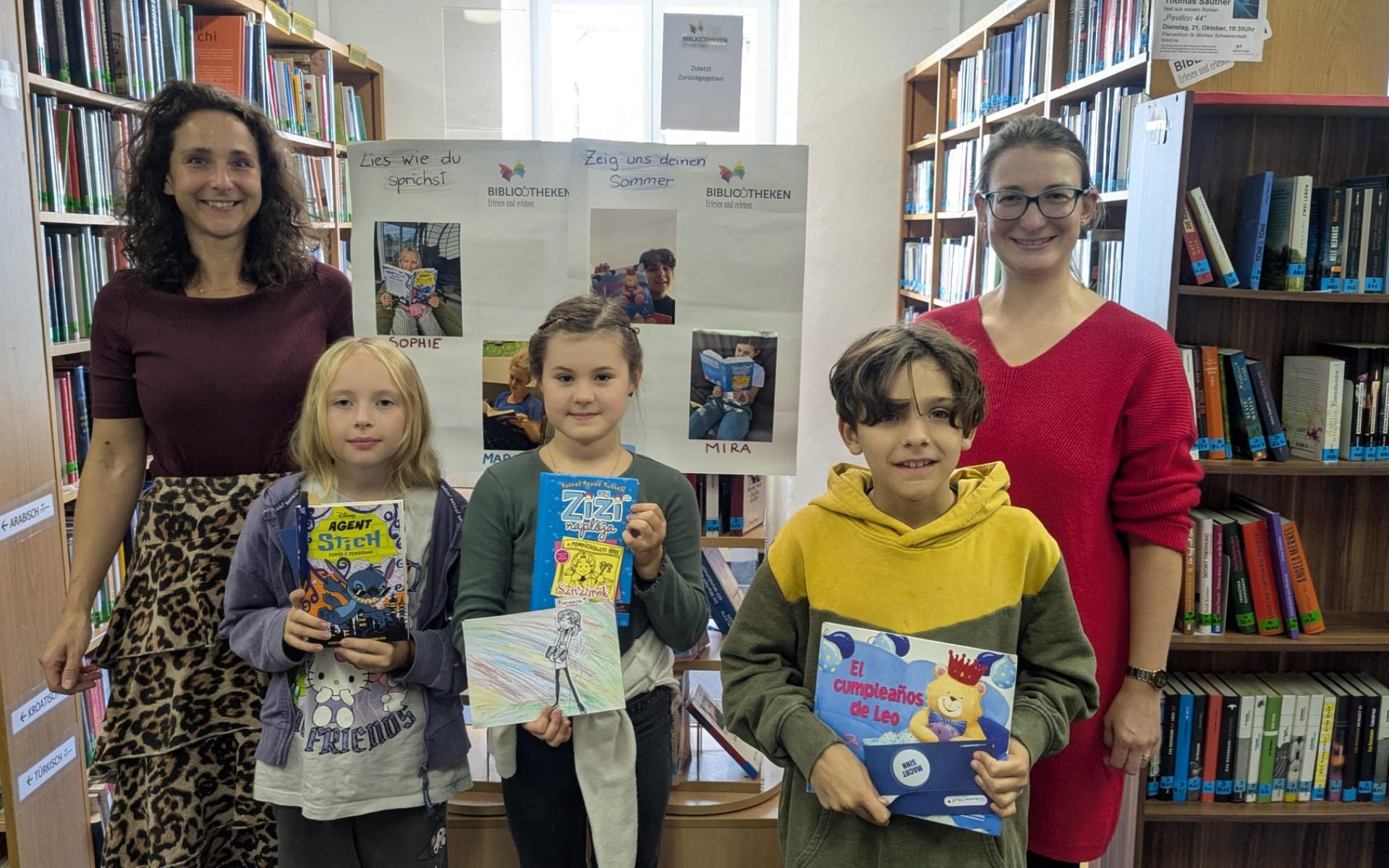 Zwei Frauen und drei Kinder mit Büchern in der Hand