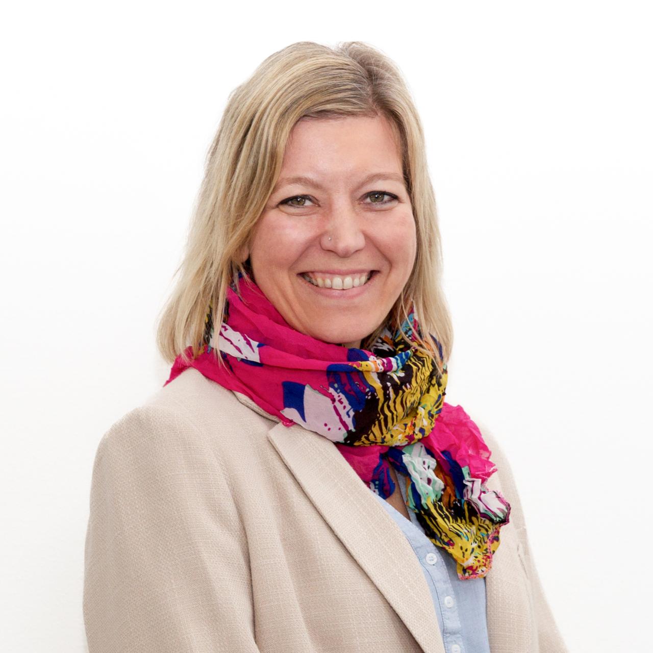 Eine Frau, die in die Kamera lächelt